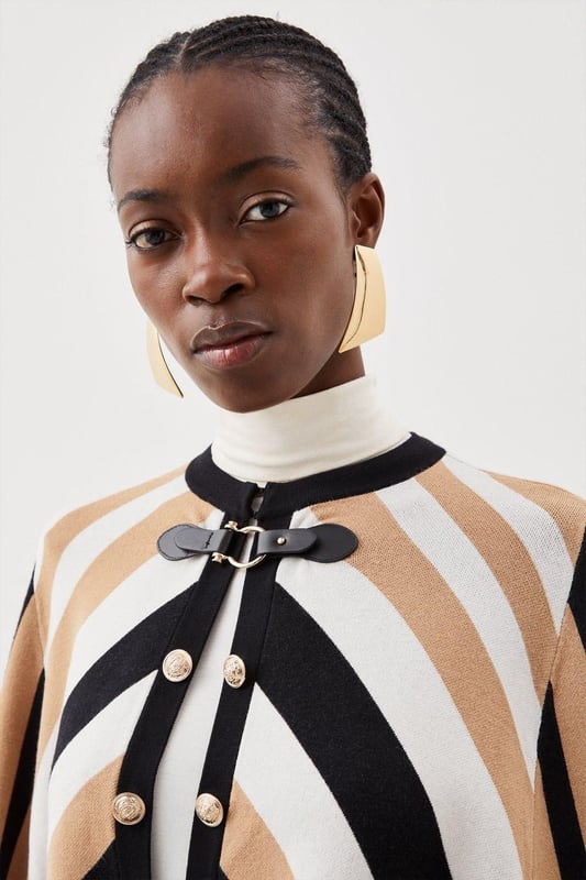 Nothing spells the changing of the seasons like a sleek cape. This covetable design is perfect for all your autumnal adventures, featuring an equestrian-style buckle fastening and cosy, knitted construction. Glossy military-inspired buttons line the front, adding to its luxe allure ? simply slip it on over your outfit for an instantly polished finish. Style: CapeDesign: PlainFabric: KnittedLength: RegularNeckline: CollarlessSleeve Length: Sleeveless Discover our blog post on the most popular coats & jackets for AW24 here.