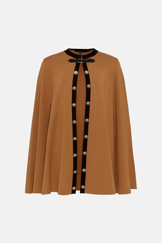 Nothing spells the changing of the seasons like a sleek cape. This covetable design is perfect for all your autumnal adventures, featuring an equestrian-style buckle fastening and cosy, knitted construction. Glossy military-inspired buttons line the front, adding to its luxe allure ? simply slip it on over your outfit for an instantly polished finish. Style: CapeDesign: PlainFabric: KnittedLength: RegularNeckline: CollarlessSleeve Length: Sleeveless Discover our blog post on the most popular coats & jackets for AW24 here.