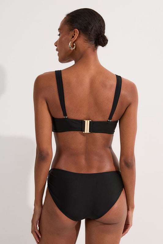 This Karen Millen bikini top combines contemporary design with practical versatility. The standout gold-tone hardware creates a luxurious focal point whilst the detachable straps offer two distinct looks - wear as a classic bandeau for minimal tan lines or attach the straps for additional support during active beach days. The gathered fabric detail adds a touch of sophistication that distinguishes this piece from ordinary swimwear. Perfect for making a statement whilst lounging poolside at exclusive resorts or during sun-soaked coastal holidays. Style with oversized sunglasses and delicate gold jewellery for a coordinated look, or layer under a sheer kaftan for elegant transitions from beach to bar. This bikini top effortlessly balances fashion-forward design with functional beachwear, ensuring you remain stylish whatever your holiday activities.   Elegant bandeau-style bikini top featuring a gold-tone metal trim at the front Versatile detachable straps allow for multiple styling options Soft gathered fabric detail Secure fit with comfortable stretch fabric Coordinating bottoms available to complete this refined beach ensemble  Matching piece sold separately.