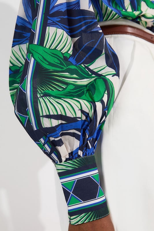 This eye-catching Karen Millen blouse showcases a vibrant mirrored floral pattern that demands attention. The lightweight voile fabric creates a fluid drape that moves with you, while the classic collared neckline adds structure to the relaxed silhouette. Style it with crisp white shorts and a slim belt for casual daytime gatherings, or tuck it into tailored trousers for a more polished look. The distinctive geometric border detailing on the cuffs provides a contemporary finishing touch that reflects Karen Millen's attention to detail.   Lightweight voile fabric with mirrored floral print throughout collared neckline with button-down front detail Geometric border detailing on cuffs Relaxed silhouette with full-length sleeves