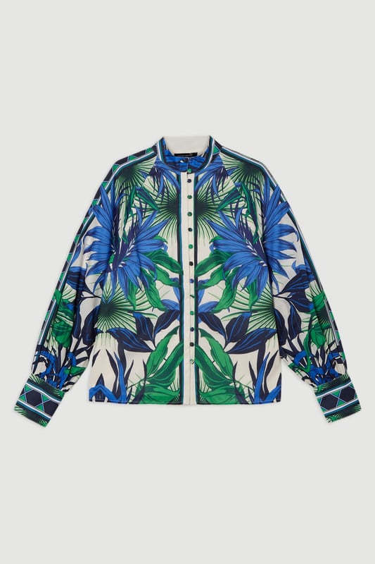 This eye-catching Karen Millen blouse showcases a vibrant mirrored floral pattern that demands attention. The lightweight voile fabric creates a fluid drape that moves with you, while the classic collared neckline adds structure to the relaxed silhouette. Style it with crisp white shorts and a slim belt for casual daytime gatherings, or tuck it into tailored trousers for a more polished look. The distinctive geometric border detailing on the cuffs provides a contemporary finishing touch that reflects Karen Millen's attention to detail.   Lightweight voile fabric with mirrored floral print throughout collared neckline with button-down front detail Geometric border detailing on cuffs Relaxed silhouette with full-length sleeves