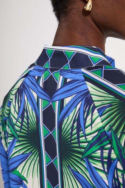 This eye-catching Karen Millen blouse showcases a vibrant mirrored floral pattern that demands attention. The lightweight voile fabric creates a fluid drape that moves with you, while the classic collared neckline adds structure to the relaxed silhouette. Style it with crisp white shorts and a slim belt for casual daytime gatherings, or tuck it into tailored trousers for a more polished look. The distinctive geometric border detailing on the cuffs provides a contemporary finishing touch that reflects Karen Millen's attention to detail.   Lightweight voile fabric with mirrored floral print throughout collared neckline with button-down front detail Geometric border detailing on cuffs Relaxed silhouette with full-length sleeves