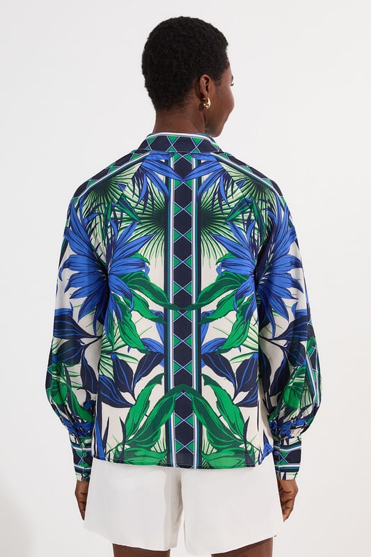 This eye-catching Karen Millen blouse showcases a vibrant mirrored floral pattern that demands attention. The lightweight voile fabric creates a fluid drape that moves with you, while the classic collared neckline adds structure to the relaxed silhouette. Style it with crisp white shorts and a slim belt for casual daytime gatherings, or tuck it into tailored trousers for a more polished look. The distinctive geometric border detailing on the cuffs provides a contemporary finishing touch that reflects Karen Millen's attention to detail.   Lightweight voile fabric with mirrored floral print throughout collared neckline with button-down front detail Geometric border detailing on cuffs Relaxed silhouette with full-length sleeves