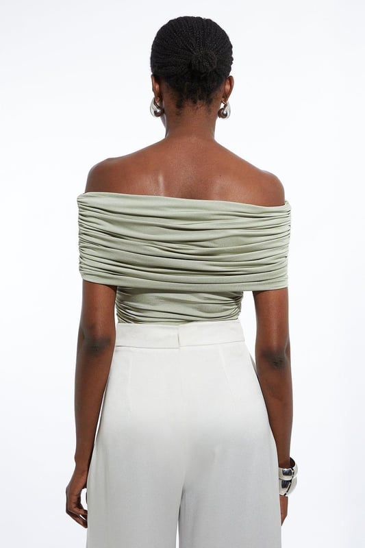 Elevate your every day wardrobe with a bodysuit, with a bodycon fit, a straight, bardot neckline which elevates the formality, and a textured, ruched design. Style it with tailored trousers or jeans and strappy heels for an occasion look that is guaranteed to turn heads wherever you step. Drapey Slinky Jersey Bardot Bodysuit High Quality, Soft Jersey Fabric Textured, Draped Design Ruched Detailing Formal Bardot Neckline Short, Off Shoulder Sleeves Bodycon Silhouette