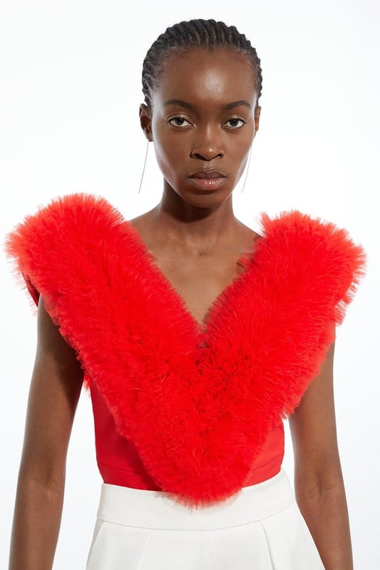 Prepare for admirable glances with this standout bodysuit. With a figure-hugging bodycon fit, and dramatic tulle detail across the shoulders, this bodysuit is set to stand out. Style with tailored trousers and strappy stilettos for an after-dark look. Bandage Figure Form Knit Tulle Detail Bodysuit Statement Tulle Detailing Deep V Neckline V Back Accent Bodycon Silhouette