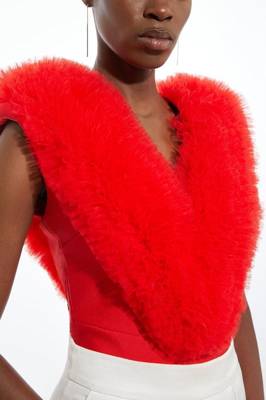 Prepare for admirable glances with this standout bodysuit. With a figure-hugging bodycon fit, and dramatic tulle detail across the shoulders, this bodysuit is set to stand out. Style with tailored trousers and strappy stilettos for an after-dark look. Bandage Figure Form Knit Tulle Detail Bodysuit Statement Tulle Detailing Deep V Neckline V Back Accent Bodycon Silhouette