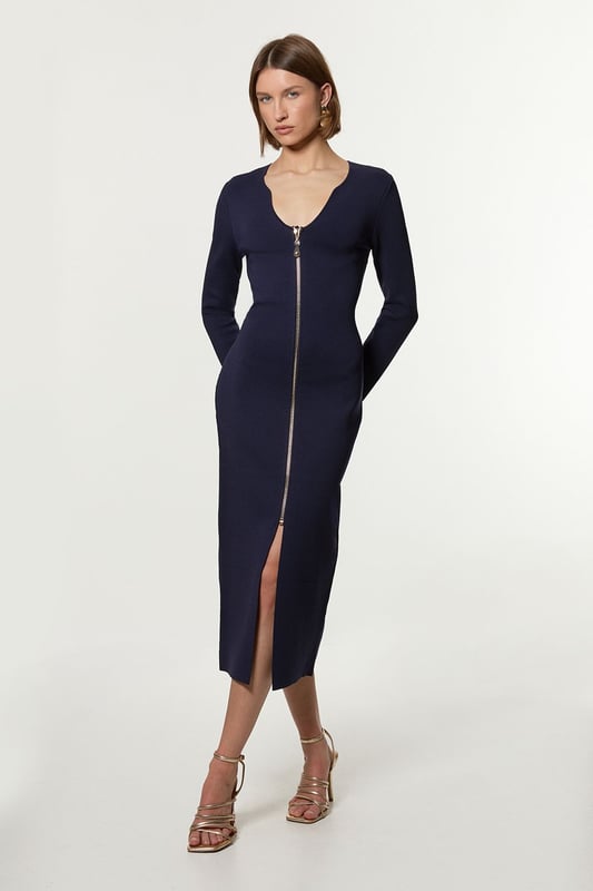 Zip Up Full Needle Knitted Dress Elevate your cold weather wardrobe in our long sleeve dress, with a fitted silhouette, metallic zip detailing, and a unique V neckline. Style it with heeled boots or chunky loafers for an elevated day to night look. Zip Up Full Needle Knitted Dress High Quality Soft Knit Fabric Flattering Figure Hugging Silhouette Rounded V Neckline Zip Front Fastening Thigh High Leg Split