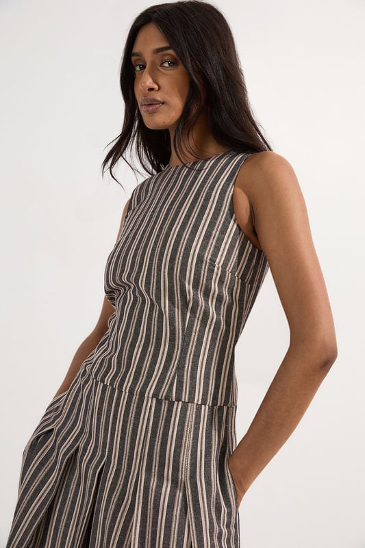 Tailored Stripe Linen Sleeveless Full Skirt Midi Dress This Karen Millen tailored midi dress combines timeless stripes with contemporary design for versatile daywear. The structured bodice flows into a beautifully pleated full skirt, creating a feminine silhouette that's both comfortable and sophisticated. Style with flat leather sandals as shown for casual family gatherings or weekend brunches. For garden parties, pair with espadrille wedges and a woven clutch. The cotton-linen blend fabric offers breathability and a natural texture perfect for warmer months. This dress transitions effortlessly from day to evening, simply swap your casual footwear for block heels and add delicate gold jewellery to complement the dress's hardware detailing. A lightweight cardigan makes this piece suitable for cooler summer evenings. Sleeveless midi dress with elegant vertical stripe pattern Sophisticated V-neckline for a flattering silhouette Full skirt design with structured pleating for graceful movement Tailored fit through bodice with defined waistline Decorative gold-tone buckle detail adds a refined finishing touch