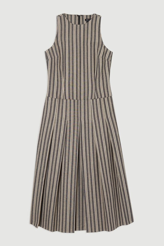 Tailored Stripe Linen Sleeveless Full Skirt Midi Dress This Karen Millen tailored midi dress combines timeless stripes with contemporary design for versatile daywear. The structured bodice flows into a beautifully pleated full skirt, creating a feminine silhouette that's both comfortable and sophisticated. Style with flat leather sandals as shown for casual family gatherings or weekend brunches. For garden parties, pair with espadrille wedges and a woven clutch. The cotton-linen blend fabric offers breathability and a natural texture perfect for warmer months. This dress transitions effortlessly from day to evening, simply swap your casual footwear for block heels and add delicate gold jewellery to complement the dress's hardware detailing. A lightweight cardigan makes this piece suitable for cooler summer evenings. Sleeveless midi dress with elegant vertical stripe pattern Sophisticated V-neckline for a flattering silhouette Full skirt design with structured pleating for graceful movement Tailored fit through bodice with defined waistline Decorative gold-tone buckle detail adds a refined finishing touch