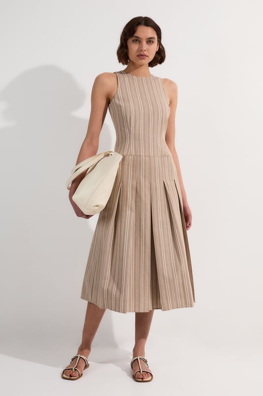 This Karen Millen tailored midi dress combines timeless stripes with contemporary design for versatile daywear. The structured bodice flows into a beautifully pleated full skirt, creating a feminine silhouette that's both comfortable and sophisticated. Style with flat leather sandals as shown for casual family gatherings or weekend brunches. For garden parties, pair with espadrille wedges and a woven clutch. The cotton-linen blend fabric offers breathability and a natural texture perfect for warmer months. This dress transitions effortlessly from day to evening, simply swap your casual footwear for block heels and add delicate gold jewellery to complement the dress's hardware detailing. A lightweight cardigan makes this piece suitable for cooler summer evenings.  Sleeveless midi dress with elegant vertical stripe pattern Sophisticated V-neckline for a flattering silhouette Full skirt design with structured pleating for graceful movement Tailored fit through bodice with defined waistline Decorative gold-tone buckle detail adds a refined finishing touch