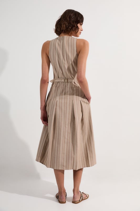 This Karen Millen tailored midi dress combines timeless stripes with contemporary design for versatile daywear. The structured bodice flows into a beautifully pleated full skirt, creating a feminine silhouette that's both comfortable and sophisticated. Style with flat leather sandals as shown for casual family gatherings or weekend brunches. For garden parties, pair with espadrille wedges and a woven clutch. The cotton-linen blend fabric offers breathability and a natural texture perfect for warmer months. This dress transitions effortlessly from day to evening, simply swap your casual footwear for block heels and add delicate gold jewellery to complement the dress's hardware detailing. A lightweight cardigan makes this piece suitable for cooler summer evenings.  Sleeveless midi dress with elegant vertical stripe pattern Sophisticated V-neckline for a flattering silhouette Full skirt design with structured pleating for graceful movement Tailored fit through bodice with defined waistline Decorative gold-tone buckle detail adds a refined finishing touch