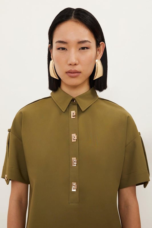 Feel formal in our shirt, with high quality cotton fabric, as well as a straight fit and short sleeves, and metallic clasp detailing down the front. Style it with anything from tailored trousers to denim jeans for looks perfect for anything from office days to dinner dates. Techno Cotton Woven Short Sleeve Hardwear Detail Shirt High Quality, Soft Cotton Fabric Flattering Straight Fit Formal Collar Accent Casual Short Sleeves Gold Clasp DetailingBrowse this seasons women's work tops or discover the full range of workwear now.Matching piece sold separately.
