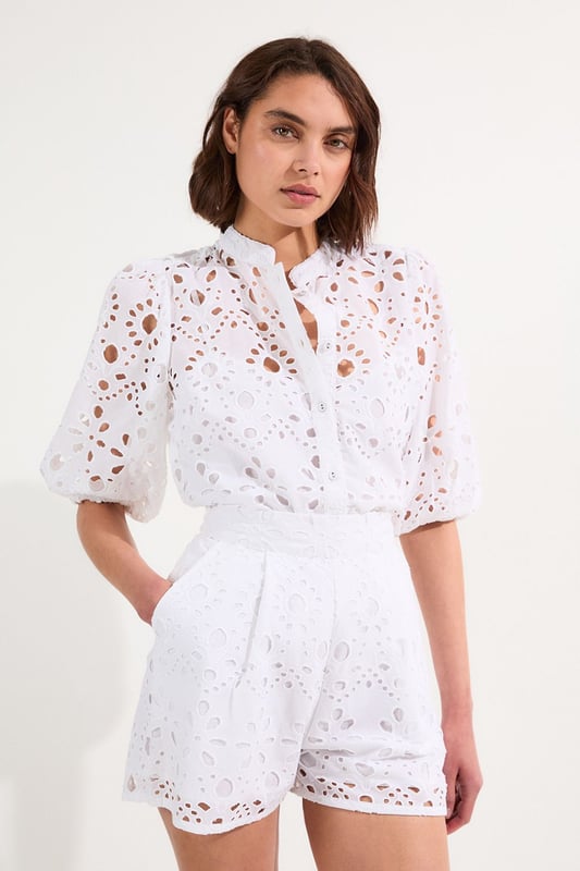 These exquisite broderie shorts from Karen Millen showcase exceptional craftsmanship with their intricate cut-out pattern. The high-waisted design creates a flattering shape that pairs with the woven shirt. For casual daywear, team with a simple tucked-in blouse and trainers for brunch with friends, or dress up with a fitted bodysuit and leather sandals for summer garden parties. The versatile length makes these shorts perfect for warm-weather holidays, simply add oversized sunglasses and a straw tote for effortless sophistication. The cotton fabric ensures breathability whilst the structured silhouette maintains shape throughout the day, making these shorts an essential addition to your warm-weather wardrobe for family gatherings and casual outings alike.  Intricate broderie anglaise detailing creates a floral pattern throughout High-waisted design with pleated front Scalloped hem with delicate cut-out pattern Side pockets