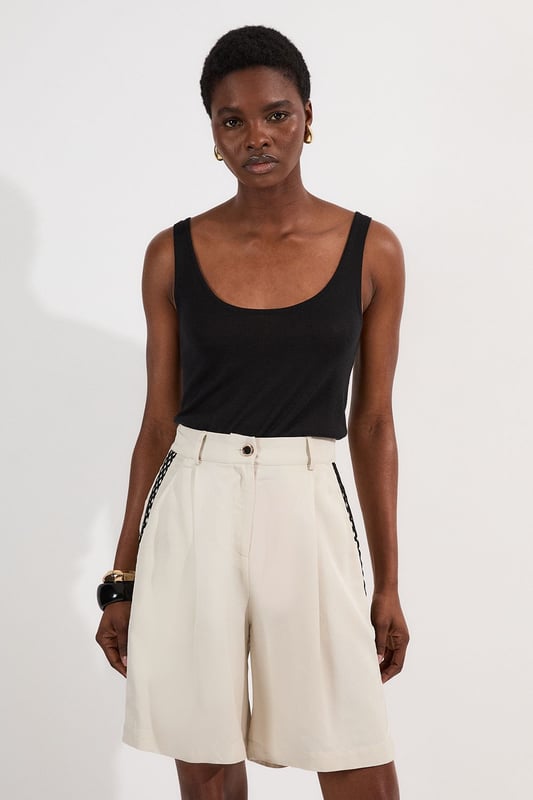 These Karen Millen shorts blend casual comfort with refined detailing, making them a versatile addition to your summer wardrobe. The contrasting lace trim inserts add visual interest to the clean, tailored silhouette, while the lightweight linen-mix fabric ensures breathability on warmer days. Style them as seen with a simple fitted vest top and strappy heels for an elevated daytime look, or pair them with a crisp white shirt and flat sandals for weekend brunches. Perfect for garden parties, coastal holidays, or casual family gatherings, these shorts offer effortless sophistication to your daywear collection.   Elegant woven shorts featuring delicate lace trim inserts High-waisted design with front pleats Secure button and zip fastening with belt loops Relaxed silhouette