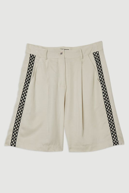 These Karen Millen shorts blend casual comfort with refined detailing, making them a versatile addition to your summer wardrobe. The contrasting lace trim inserts add visual interest to the clean, tailored silhouette, while the lightweight linen-mix fabric ensures breathability on warmer days. Style them as seen with a simple fitted vest top and strappy heels for an elevated daytime look, or pair them with a crisp white shirt and flat sandals for weekend brunches. Perfect for garden parties, coastal holidays, or casual family gatherings, these shorts offer effortless sophistication to your daywear collection.   Elegant woven shorts featuring delicate lace trim inserts High-waisted design with front pleats Secure button and zip fastening with belt loops Relaxed silhouette