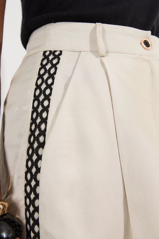 These Karen Millen shorts blend casual comfort with refined detailing, making them a versatile addition to your summer wardrobe. The contrasting lace trim inserts add visual interest to the clean, tailored silhouette, while the lightweight linen-mix fabric ensures breathability on warmer days. Style them as seen with a simple fitted vest top and strappy heels for an elevated daytime look, or pair them with a crisp white shirt and flat sandals for weekend brunches. Perfect for garden parties, coastal holidays, or casual family gatherings, these shorts offer effortless sophistication to your daywear collection.   Elegant woven shorts featuring delicate lace trim inserts High-waisted design with front pleats Secure button and zip fastening with belt loops Relaxed silhouette
