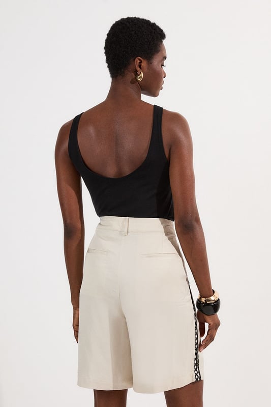 These Karen Millen shorts blend casual comfort with refined detailing, making them a versatile addition to your summer wardrobe. The contrasting lace trim inserts add visual interest to the clean, tailored silhouette, while the lightweight linen-mix fabric ensures breathability on warmer days. Style them as seen with a simple fitted vest top and strappy heels for an elevated daytime look, or pair them with a crisp white shirt and flat sandals for weekend brunches. Perfect for garden parties, coastal holidays, or casual family gatherings, these shorts offer effortless sophistication to your daywear collection.   Elegant woven shorts featuring delicate lace trim inserts High-waisted design with front pleats Secure button and zip fastening with belt loops Relaxed silhouette