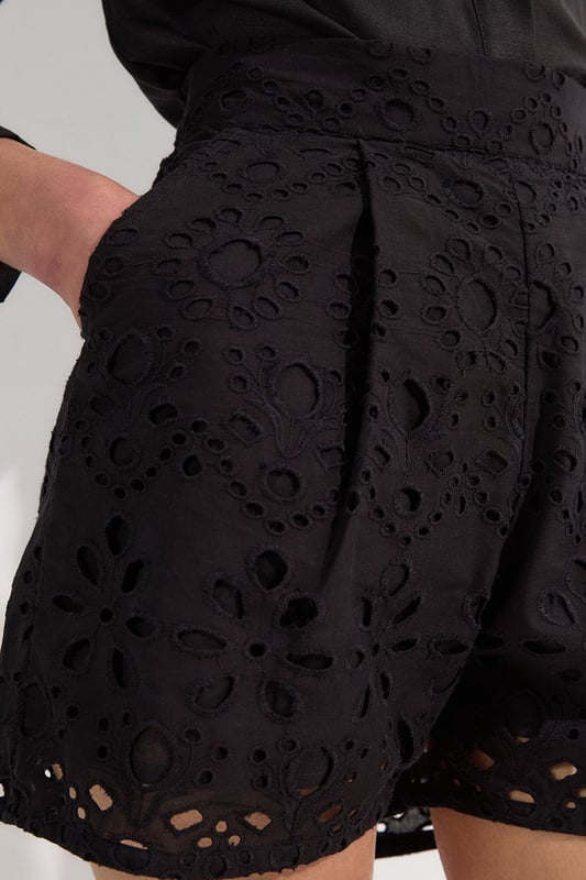 These exquisite broderie shorts from Karen Millen showcase exceptional craftsmanship with their intricate cut-out pattern. The high-waisted design creates a flattering shape that pairs with the woven shirt. For casual daywear, team with a simple tucked-in blouse and trainers for brunch with friends, or dress up with a fitted bodysuit and leather sandals for summer garden parties. The versatile length makes these shorts perfect for warm-weather holidays, simply add oversized sunglasses and a straw tote for effortless sophistication. The cotton fabric ensures breathability whilst the structured silhouette maintains shape throughout the day, making these shorts an essential addition to your warm-weather wardrobe for family gatherings and casual outings alike.  Intricate broderie anglaise detailing creates a floral pattern throughout High-waisted design with pleated front Scalloped hem with delicate cut-out pattern Side pockets