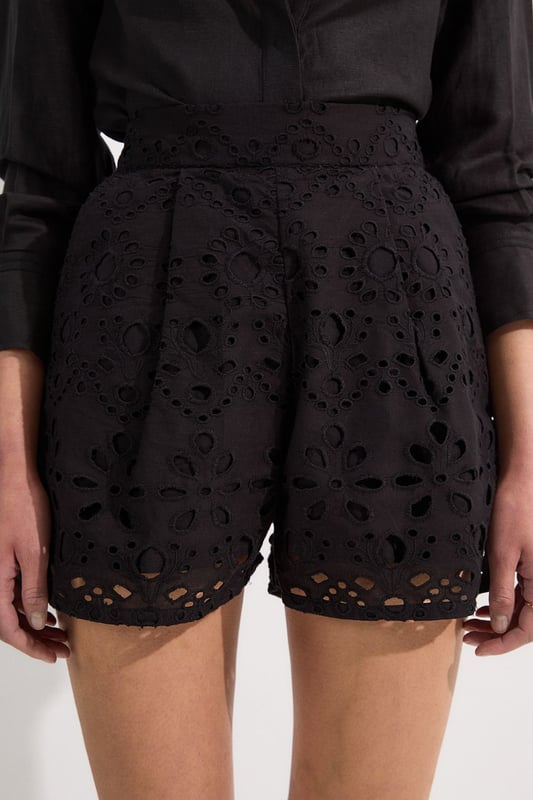These exquisite broderie shorts from Karen Millen showcase exceptional craftsmanship with their intricate cut-out pattern. The high-waisted design creates a flattering shape that pairs with the woven shirt. For casual daywear, team with a simple tucked-in blouse and trainers for brunch with friends, or dress up with a fitted bodysuit and leather sandals for summer garden parties. The versatile length makes these shorts perfect for warm-weather holidays, simply add oversized sunglasses and a straw tote for effortless sophistication. The cotton fabric ensures breathability whilst the structured silhouette maintains shape throughout the day, making these shorts an essential addition to your warm-weather wardrobe for family gatherings and casual outings alike.  Intricate broderie anglaise detailing creates a floral pattern throughout High-waisted design with pleated front Scalloped hem with delicate cut-out pattern Side pockets