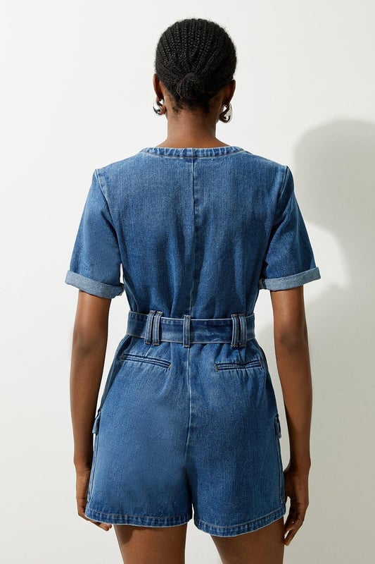 Elevate your summer wardrobe in our playsuit, with high quality denim fabric, featuring a belted waistline, as well as a utility design and relaxed fit shorts. Styles well with trainers or sandals for a summer outfit that can be worn again and again. Denim Cargo Pocket Belted Playsuit High Quality Denim Fabric Flattering Relaxed Fit Summery Short Sleeves Unique Cargo Style Zip Front Fastenings Belted Waist for a Cinched Silhouette