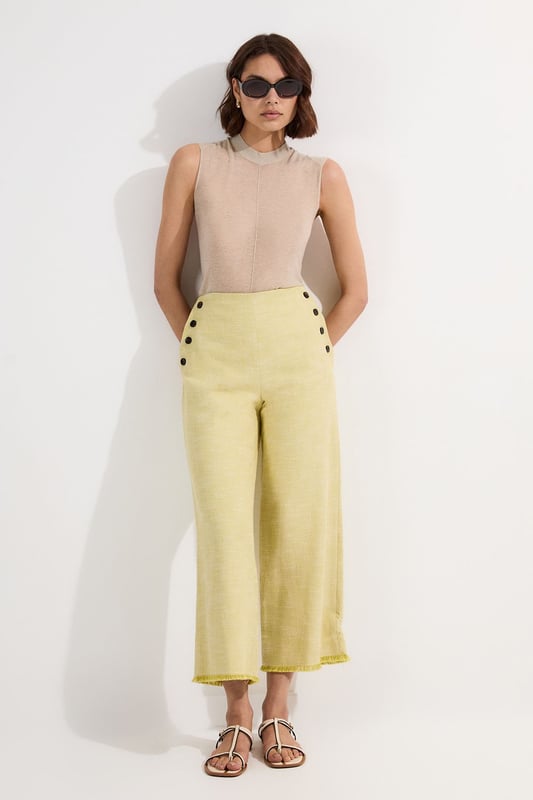 These cropped wide-leg trousers create a modern, relaxed shape while the high waistband defines your silhouette. Style with a fitted tank top for daytime sophistication, or pair with a crisp white shirt for a more structured look. The decorative button detailing adds a distinctive touch that reflects Karen Millen's attention to refined details. Perfect for family brunches, or casual workplace settings, these versatile trousers transition effortlessly from day to evening when paired with a silk blouse and strappy sandals. The neutral tone makes them an excellent foundation piece for your wardrobe, working with both bold and subtle colour palettes throughout the seasons.   Tailored wide leg trousers featuring distinctive button detailing Cropped length design High-waisted silhouette Textured tweed fabric  Matching piece sold separately.
