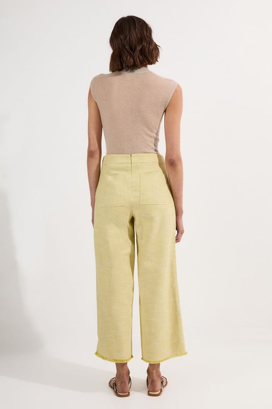 These cropped wide-leg trousers create a modern, relaxed shape while the high waistband defines your silhouette. Style with a fitted tank top for daytime sophistication, or pair with a crisp white shirt for a more structured look. The decorative button detailing adds a distinctive touch that reflects Karen Millen's attention to refined details. Perfect for family brunches, or casual workplace settings, these versatile trousers transition effortlessly from day to evening when paired with a silk blouse and strappy sandals. The neutral tone makes them an excellent foundation piece for your wardrobe, working with both bold and subtle colour palettes throughout the seasons.   Tailored wide leg trousers featuring distinctive button detailing Cropped length design High-waisted silhouette Textured tweed fabric  Matching piece sold separately.