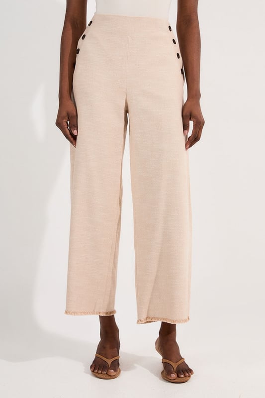 These cropped wide-leg trousers create a modern, relaxed shape while the high waistband defines your silhouette. Style with a fitted tank top for daytime sophistication, or pair with a crisp white shirt for a more structured look. The decorative button detailing adds a distinctive touch that reflects Karen Millen's attention to refined details. Perfect for family brunches, or casual workplace settings, these versatile trousers transition effortlessly from day to evening when paired with a silk blouse and strappy sandals. The neutral tone makes them an excellent foundation piece for your wardrobe, working with both bold and subtle colour palettes throughout the seasons.   Tailored wide leg trousers featuring distinctive button detailing Cropped length design High-waisted silhouette Textured tweed fabric  Matching piece sold separately.