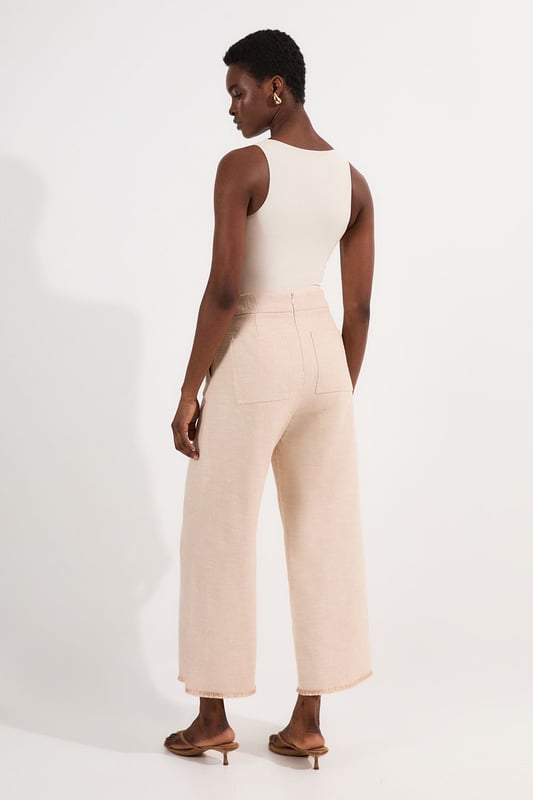 These cropped wide-leg trousers create a modern, relaxed shape while the high waistband defines your silhouette. Style with a fitted tank top for daytime sophistication, or pair with a crisp white shirt for a more structured look. The decorative button detailing adds a distinctive touch that reflects Karen Millen's attention to refined details. Perfect for family brunches, or casual workplace settings, these versatile trousers transition effortlessly from day to evening when paired with a silk blouse and strappy sandals. The neutral tone makes them an excellent foundation piece for your wardrobe, working with both bold and subtle colour palettes throughout the seasons.   Tailored wide leg trousers featuring distinctive button detailing Cropped length design High-waisted silhouette Textured tweed fabric  Matching piece sold separately.