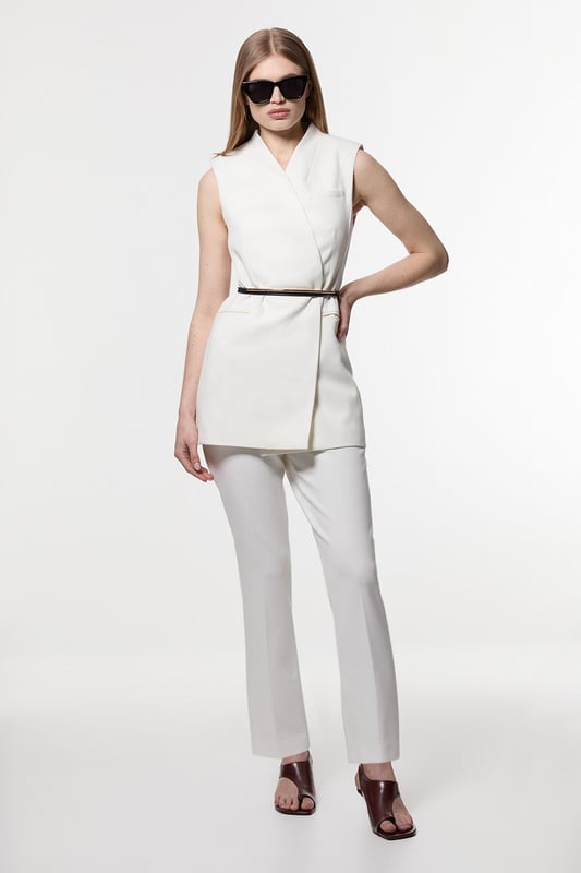 These Karen Millen tailored trousers combine professional polish with modern comfort. The slim leg design creates a refined silhouette that transitions seamlessly from boardroom to evening engagements. Style with a coordinating blazer and pointed flats for a sophisticated workwear ensemble, as shown by our model, or pair with a crisp white shirt and block heels for client meetings. The stretch-enhanced fabric allows for comfortable movement whilst maintaining structure, ideal for long days at the office. For after-work occasions, simply add statement jewellery and swap flats for elegant heels. These versatile trousers form the foundation of a capsule workwear wardrobe, offering endless styling possibilities whilst maintaining a distinctly professional appearance. Their timeless design ensures they'll remain a wardrobe staple for seasons to come.  Tailored slim leg design with clean, streamlined silhouette Stretch fabric blend for exceptional comfort and movement Sleek waistband with subtle front closure Versatile 60cm length perfect for pairing with flats or heels Sophisticated straight-leg cut that maintains its shape throughout the day  Matching piece sold separately.