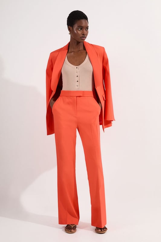 These Karen Millen tailored kick flare trousers present the perfect balance of contemporary style and classic workwear sophistication. The high-rise waistband creates a flattering shape that elongates the legs, while the subtle flare adds a modern twist to traditional office attire. Style them with a fitted button-front vest and coordinating blazer for a powerful suited look, or pair them with a crisp cotton shirt and court shoes for everyday elegance. The versatile design transitions seamlessly from important meetings to after-work gatherings, simply swap your structured tote for a clutch and add statement jewellery.  Tailored high-waisted design Kick flare shape Clean, minimalist styling Viscose-blend fabric