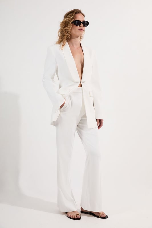 These Karen Millen tailored kick flare trousers present the perfect balance of contemporary style and classic workwear sophistication. The high-rise waistband creates a flattering shape that elongates the legs, while the subtle flare adds a modern twist to traditional office attire. Style them with a fitted button-front vest and coordinating blazer for a powerful suited look, or pair them with a crisp cotton shirt and court shoes for everyday elegance. The versatile design transitions seamlessly from important meetings to after-work gatherings, simply swap your structured tote for a clutch and add statement jewellery.  Tailored high-waisted design Kick flare shape Clean, minimalist styling Viscose-blend fabric