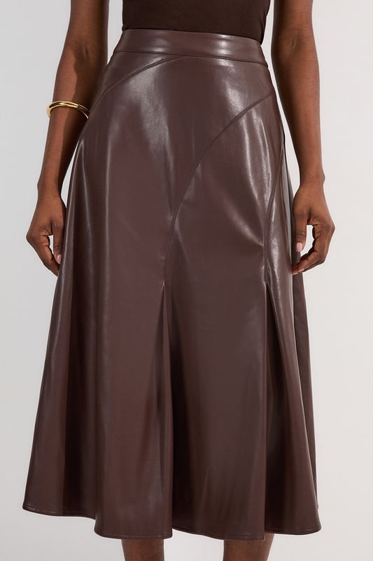 This Karen Millen faux leather midi skirt combines timeless elegance with contemporary edge. The full silhouette creates a dramatic swish with every step, while the high waistline accentuates your natural curves. Style with a fitted top for a balanced silhouette that highlights the skirt's voluminous design. For casual gatherings, pair it with a simple knit jumper and ankle boots, or dress it up with a crisp blouse and block heels for dinner dates. The versatile midi length works with both flats and heels, making this piece adaptable for family gatherings or weekend brunches. Add a cropped jacket and statement jewellery to transform this skirt into an ensemble that transitions effortlessly from day to evening wear.  Faux leather midi skirt with a full, flowing silhouette High-waisted design Elegant pleating detail Midi length Smooth finish with a subtle sheen