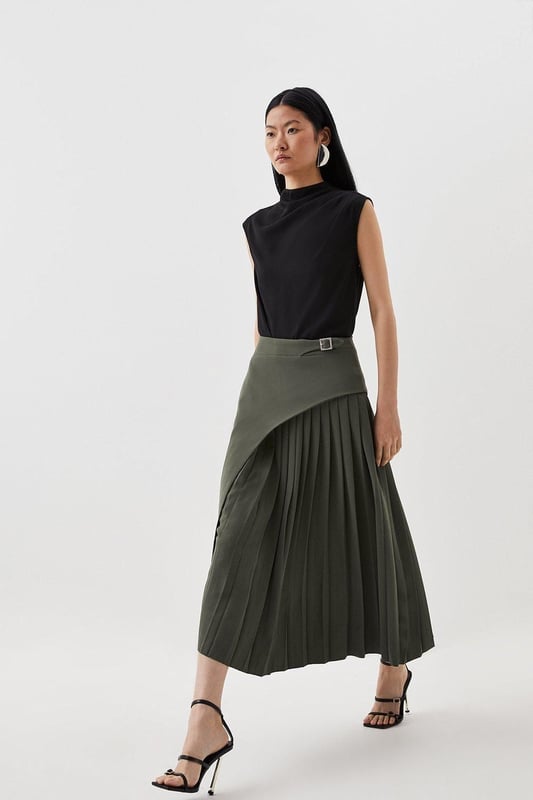 Feel elegant in our midi skirt, with a universally flattering silhouette, pleated detailing, and a high waistline, perfect for getting a little dressed up. Style this piece with strappy heels for an outfit that will turn heads from office days to upcoming occasions and events. Tailored Buckle Detail Pleated Midi Skirt Formal, Flowing Fit High Waistline Unique Pleated Panel Midi Length Metallic Buckle at WaistlineBrowse this seasons work skirts or discover the full range of workwear now.