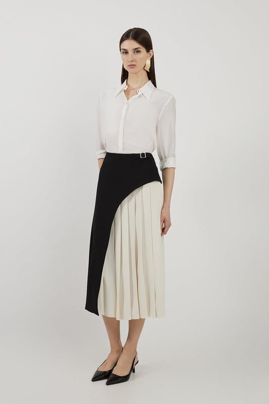 Feel elegant in our midi skirt, with a universally flattering silhouette, pleated detailing, and a high waistline, perfect for getting a little dressed up. Style this piece with strappy heels for an outfit that will turn heads from office days to upcoming occasions and events. Tailored Buckle Detail Pleated Midi Skirt Formal, Flowing Fit High Waistline Unique Pleated Panel Midi Length Metallic Buckle at WaistlineBrowse this seasons work skirts or discover the full range of workwear now.