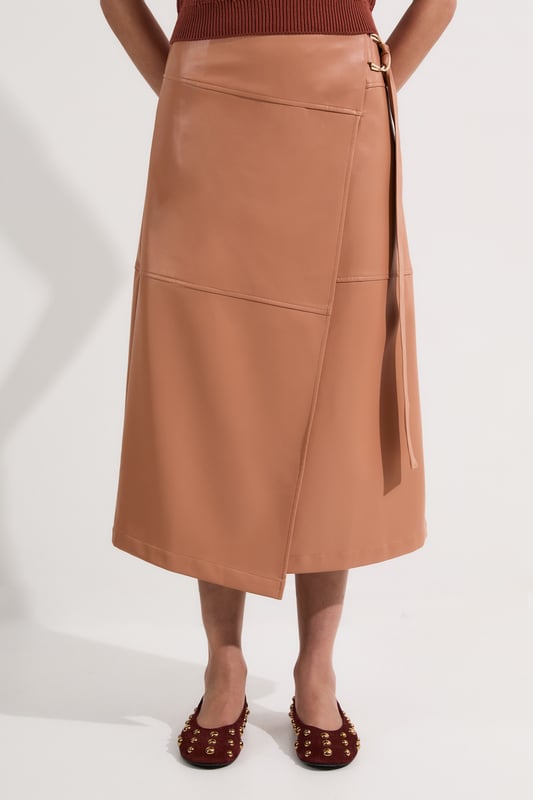 This Karen Millen wrap midi skirt showcases sophisticated urban style with its distinctive tie detail and statement buckle. The asymmetric wrap design creates a flattering silhouette. For family gatherings or brunches with friends, team with a fine knit jumper and trainers for an effortlessly stylish look. The versatile midi length makes this piece ideal for transitional weather, while the faux leather texture adds a contemporary touch to your wardrobe.   Striking wrap design with elegant tie detail Distinctive buckle hardware Midi length Faux leather