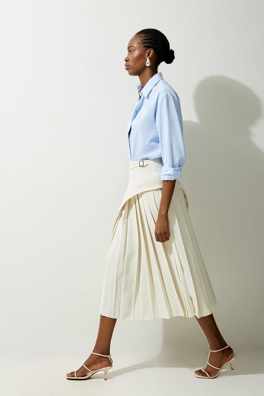 Feel elegant in our midi skirt, with a universally flattering silhouette, pleated detailing, and a high waistline, perfect for getting a little dressed up. Style this piece with strappy heels for an outfit that will turn heads from office days to upcoming occasions and events. Tailored Buckle Detail Pleated Midi Skirt Formal, Flowing Fit High Waistline Unique Pleated Panel Midi Length Metallic Buckle at WaistlineBrowse this seasons work skirts or discover the full range of workwear now.