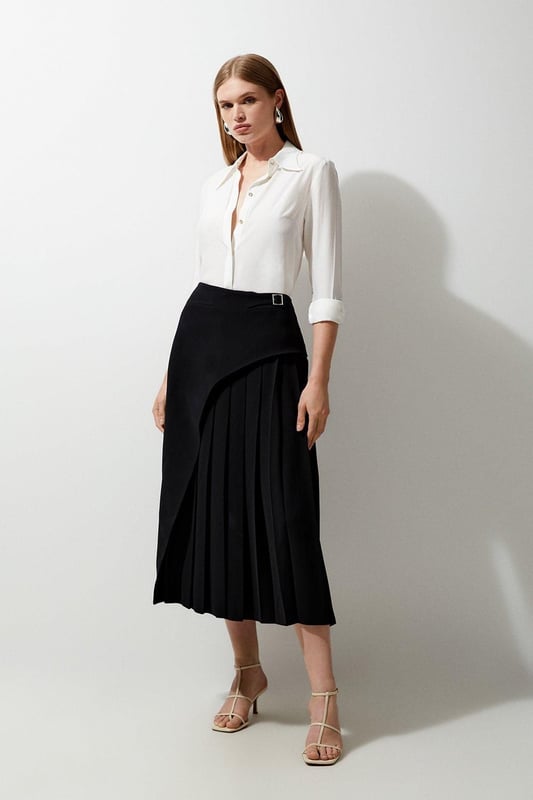 Feel elegant in our midi skirt, with a universally flattering silhouette, pleated detailing, and a high waistline, perfect for getting a little dressed up. Style this piece with strappy heels for an outfit that will turn heads from office days to upcoming occasions and events. Tailored Buckle Detail Pleated Midi Skirt Formal, Flowing Fit High Waistline Unique Pleated Panel Midi Length Metallic Buckle at WaistlineBrowse this seasons work skirts or discover the full range of workwear now.