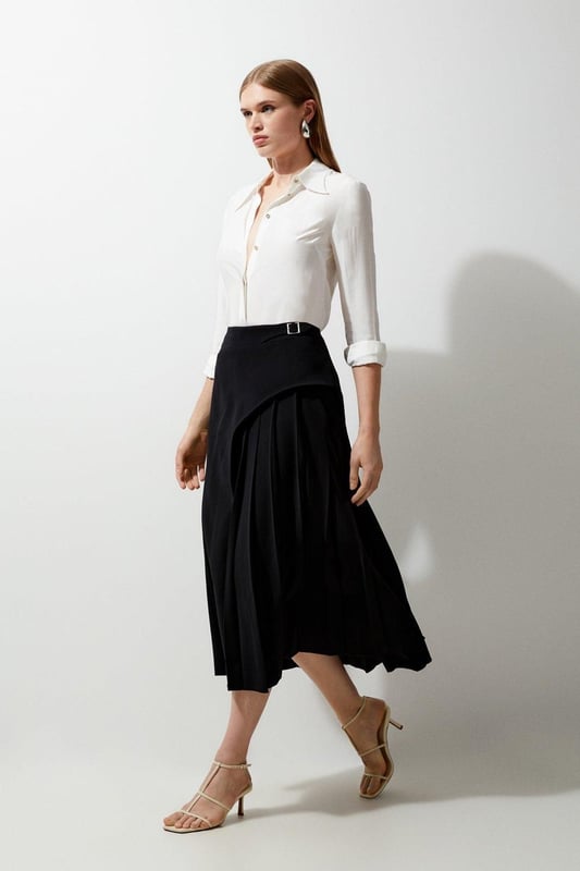 Feel elegant in our midi skirt, with a universally flattering silhouette, pleated detailing, and a high waistline, perfect for getting a little dressed up. Style this piece with strappy heels for an outfit that will turn heads from office days to upcoming occasions and events. Tailored Buckle Detail Pleated Midi Skirt Formal, Flowing Fit High Waistline Unique Pleated Panel Midi Length Metallic Buckle at WaistlineBrowse this seasons work skirts or discover the full range of workwear now.