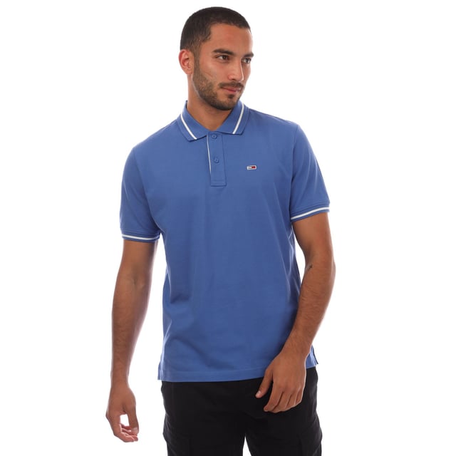 Mens Tommy Jeans Regular Fit Tipped Polo Shirt in blue.- Ribbed polo collar.- Two button placket.- Short sleeves with ribbed cuffs.- Contrast tipping at collar and cuffs- Embroidered Tommy Jeans flag patch at left chest.- Even vented hem.- Soft and comfortable cotton piqué fabric  made with at least 95% regenerative cotton.- Regular fit.- 100% Cotton.  Machine washable.- Ref: DM0DM20745C6E