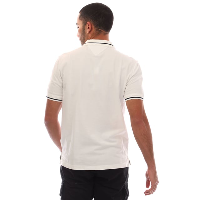 Mens Tommy Jeans Regular Fit Tipped Polo Shirt in white.- Ribbed polo collar.- Two button placket.- Short sleeves with ribbed cuffs.- Contrast tipping at collar and cuffs- Embroidered Tommy Jeans flag patch at left chest.- Even vented hem.- Soft and comfortable cotton piqué fabric  made with at least 95% regenerative cotton.- Regular fit.- 100% Cotton.  Machine washable.- Ref: DM0DM20745YBL