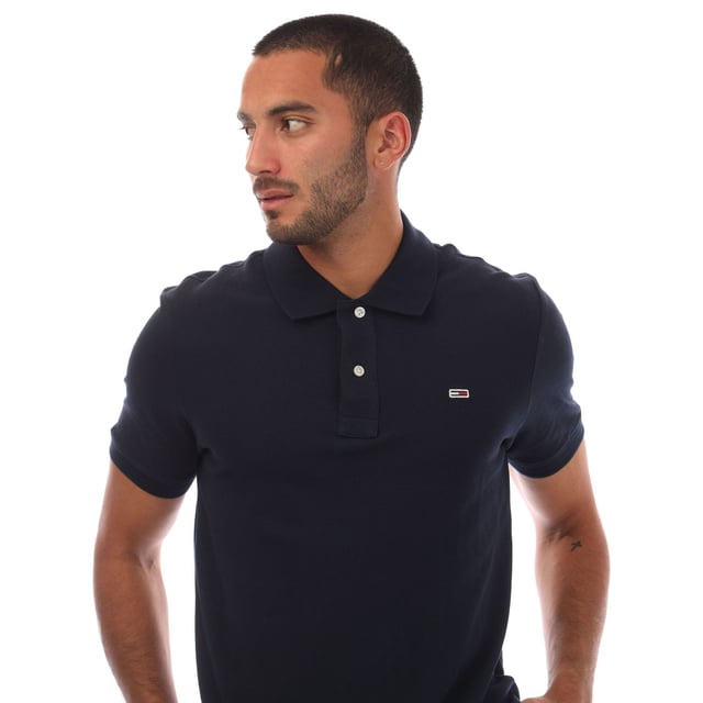 Mens Tommy Jeans Casual Polo Shirt in navy.- Ribbed polo collar.- Short sleeves with ribbed cuffs.- Two button placket.- Tommy Hilfiger flag embroidery on chest.- Split hem.- Regular fit.- 100% Cotton.- Ref.: DM0DM20763C1G