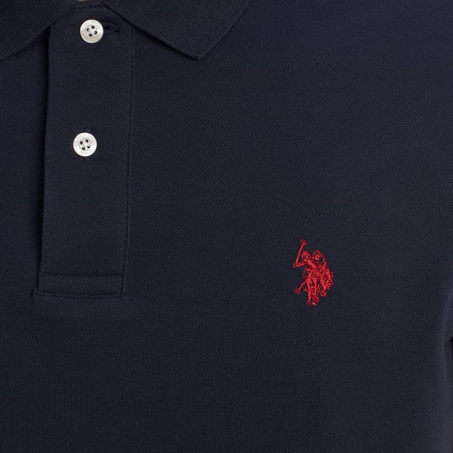 Inspirado en la herencia deportiva de la marca, este polo U.S. Polo Assn. ofrece una combinación perfecta de tradición y modernidad. Diseñado para el hombre que valora la autenticidad, su corte impecable y sus detalles bordados lo convierten en una prenda esencial del armario contemporáneo.

Detalles:
- Cuello clásico tipo polo con tapeta de dos botones.
- Mangas cortas.
- Detalle de ribete en el interior del cuello.
- Logo U.S. Polo Assn. bordado en el pecho.
- Corte regular que garantiza comodidad y libertad de movimiento.
- Tejido de piqué transpirable de alta calidad.

En U.S. Polo Assn., cada prenda cuenta una historia de autenticidad, tradición y estilo deportivo. Este polo hombre no es solo una prenda básica: representa el legado oficial del deporte del polo y refleja nuestra pasión por la calidad, el diseño y la elegancia casual. Viste con identidad, viste con historia.
 Composición: 100% Algodón
 Cuidados:
Lavar a máquina en frío (máx. 30 °C).
No usar lejía.
Planchar a temperatura baja si es necesario.
Secar al aire, evitar secadora.