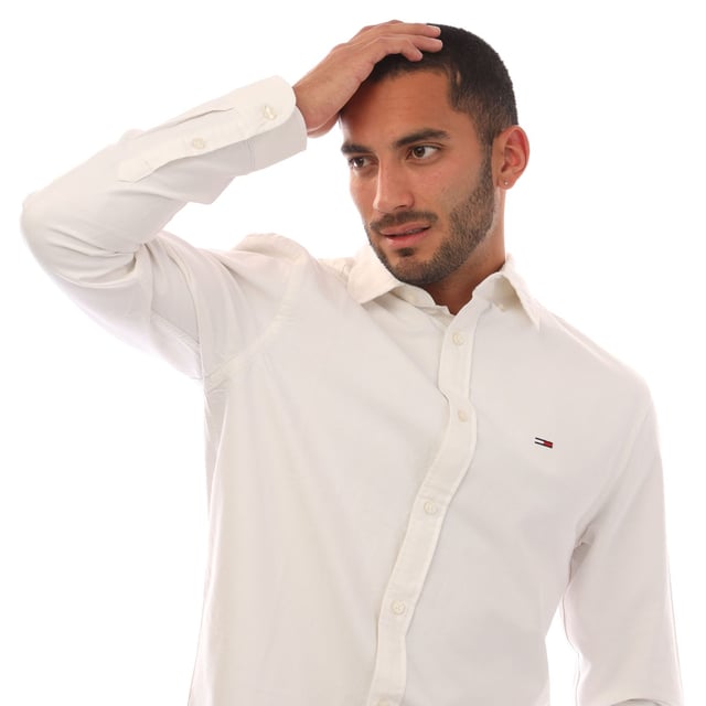 Mens Tommy Jeans Regular Fit Button Down Oxford Shirt in ecru.- Button-down collar.- Long sleeves.- Rounded one-button cuffs.- Box pleat on back.- Rounded hem.- Tommy flag embroidery on chest.- Regular fit.- 100% Cotton.  Machine washable.- Ref: DM0DM21298YBL