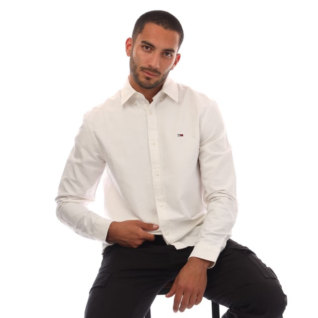 Mens Tommy Jeans Regular Fit Button Down Oxford Shirt in ecru.- Button-down collar.- Long sleeves.- Rounded one-button cuffs.- Box pleat on back.- Rounded hem.- Tommy flag embroidery on chest.- Regular fit.- 100% Cotton.  Machine washable.- Ref: DM0DM21298YBL