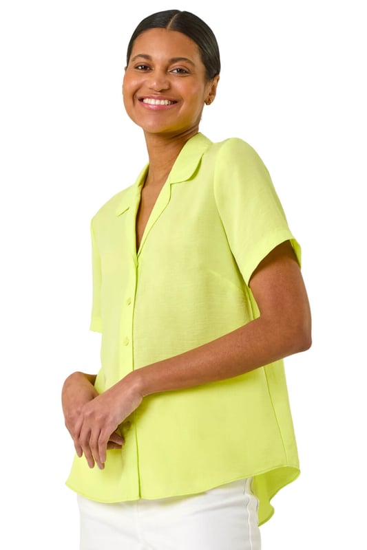Collared Short Sleeve Blouse from Roman. Get ready to elevate your Summer wardrobe with this smart short sleeve blouse! Featuring a classic v-neckline with a trendy pyjama-style collar, this blouse is perfect for any occasion. The button front detail adds a stylish touch, while the comfortable woven fabric ensures a flattering blouse shape. Pair it with wide leg trousers and sandals for a fashionable look that exudes sophistication!