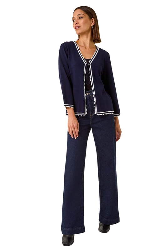 Scallop Edge Tie Cardigan from Roman. Add a touch of elegance to your Autumn/Winter wardrobe with this charming scallop edge cardigan. This lightweight piece features a unique contrast knit detail and is designed in an edge to edge style with a tie detail and delicate scallop edge. Perfect for layering, this versatile piece pairs beautifully with a simple t-shirt and jeans for a chic and polished look.