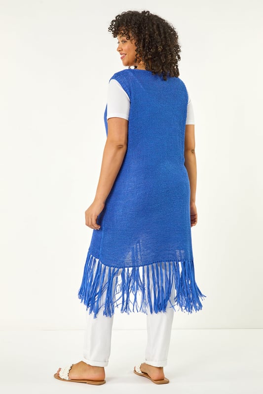 Curve Crochet Knit Tassel Cardigan from Roman. This Curve sleeveless longline cardigan features an edge to edge design with a single button fastening at the centre front for a sleek, minimalist look. The tassel hem adds a playful, boho touch, while the crochet knit fabric gives it a relaxed, textured feel. Pair it with a simple t-shirt and jeans for a casual yet stylish outfit that's perfect for layering on cooler days!