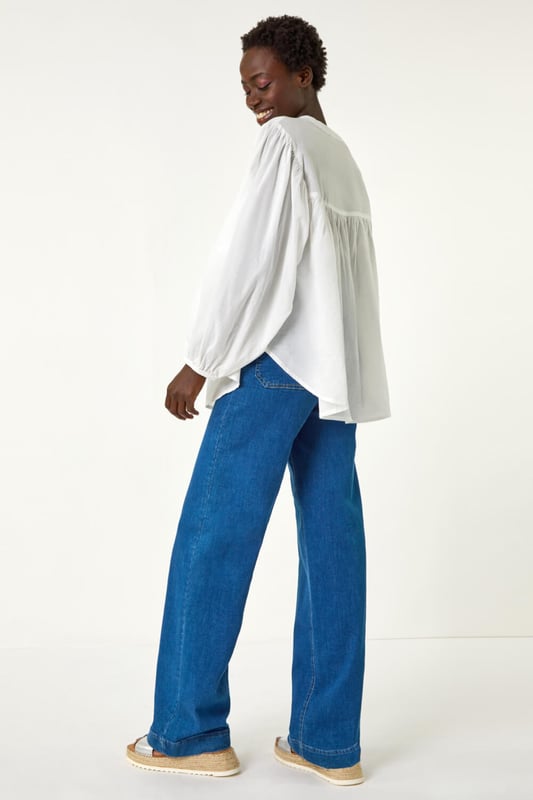 Pleat Detail Button Through Blouse from Roman. Add a touch of sophistication to your wardrobe with this pleat detail button-through blouse. Crafted from a soft cotton fabric, this classic round neckline design features long sleeves to keep you warm during the Autumn Winter. Complete with stylish front pleat detail and trendy button-through opening, this blouse adds a subtle elegance to your outfit. Style effortlessly with jeggings and ankle boots for a complete fall look!