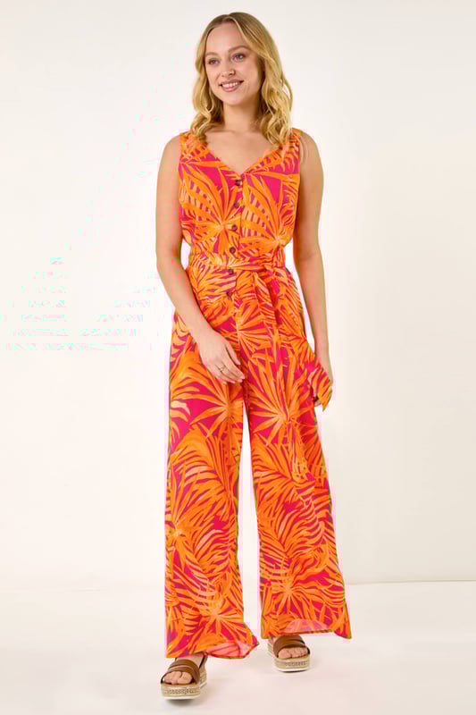 Dusk Palm Print Belted Jumpsuit from Roman. Get ready to make a statement in this chic palm print jumpsuit for the upcoming Spring/Summer season. Featuring a flattering v-neck and sleeveless design, this woven jumpsuit is perfect for sunny days. The belted waist detail adds a touch of elegance and ensures a great fit. Complete your look with sandals and a trendy denim jacket for effortless style!