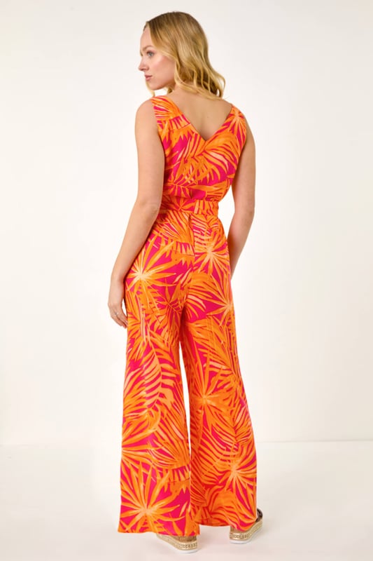 Dusk Palm Print Belted Jumpsuit from Roman. Get ready to make a statement in this chic palm print jumpsuit for the upcoming Spring/Summer season. Featuring a flattering v-neck and sleeveless design, this woven jumpsuit is perfect for sunny days. The belted waist detail adds a touch of elegance and ensures a great fit. Complete your look with sandals and a trendy denim jacket for effortless style!